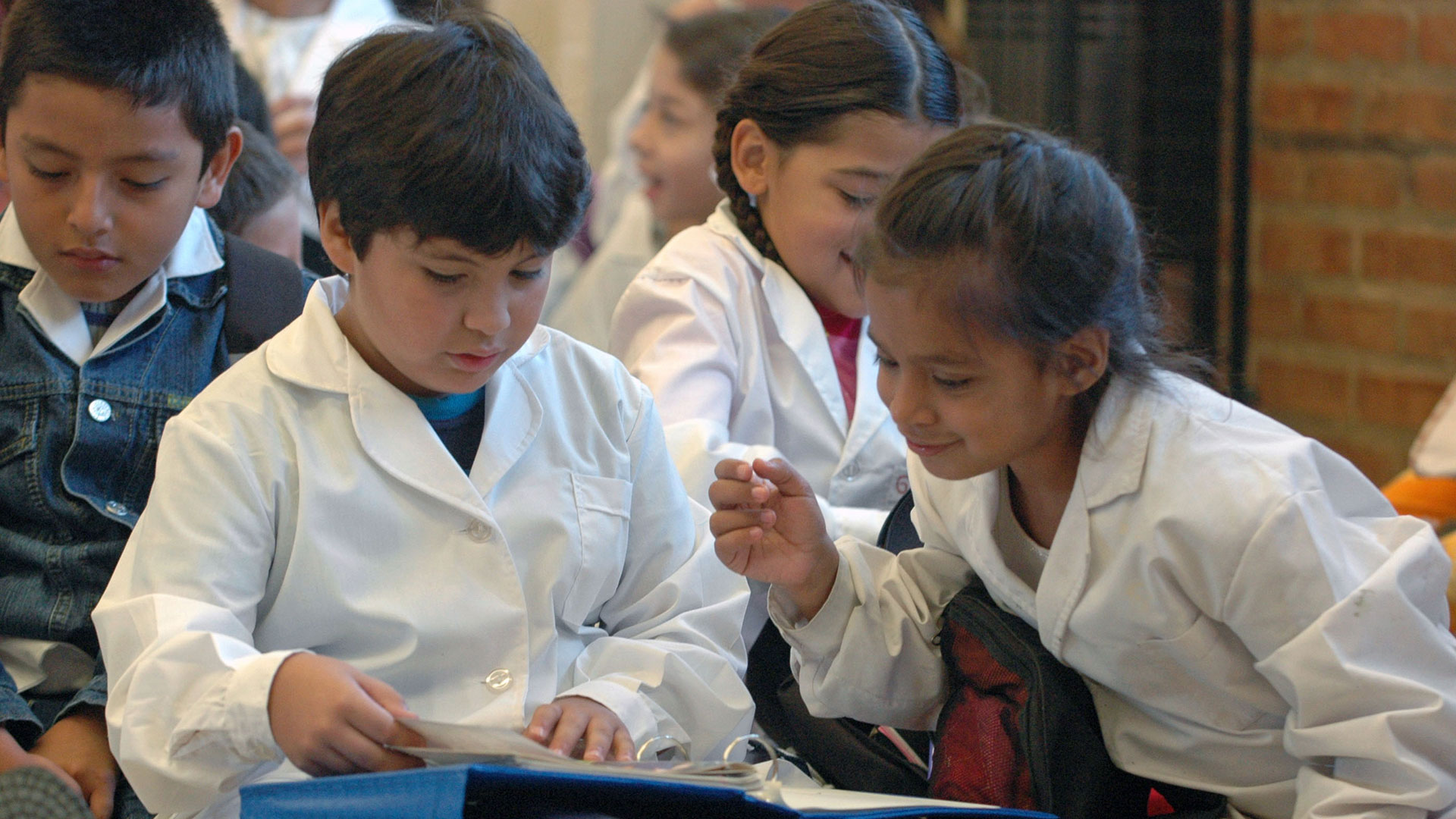 Niño con auriculares sonriendo frente a una computadora